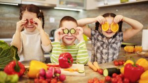 niños felices con alimentos ricos en vitaminas